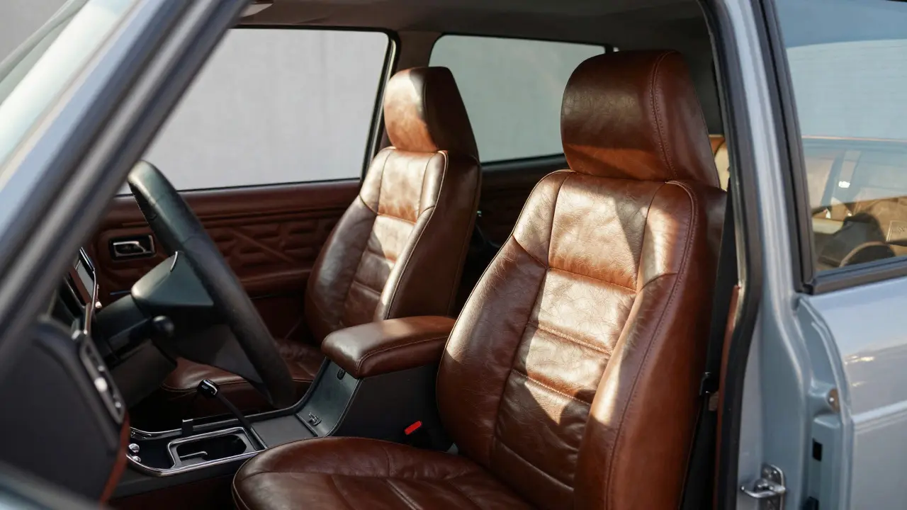 Close-up of a 1970s SUV interior featuring leather bucket seats and rugged chassis